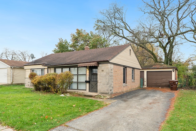 view of front of house with a garage, an outbuilding, and a front yard