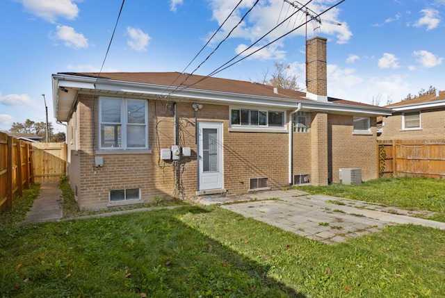 back of house with central AC unit, a patio, and a yard