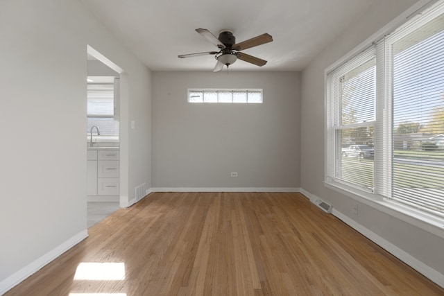 unfurnished room featuring light hardwood / wood-style floors, ceiling fan, and sink