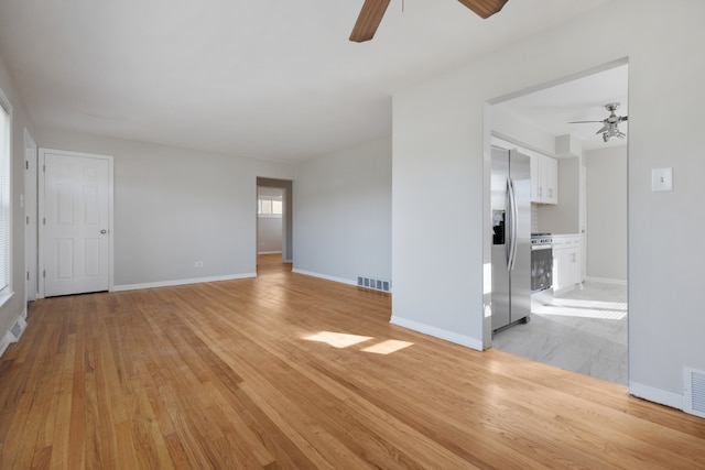 unfurnished living room featuring light wood-type flooring and ceiling fan