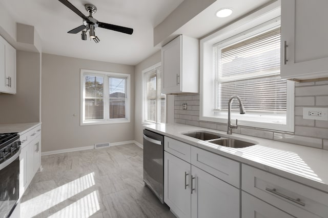 kitchen with white cabinets, decorative backsplash, stainless steel dishwasher, and sink