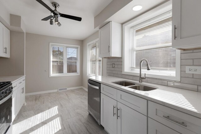 1367 Buffalo Ave, Calumet City, IL 60409 - kitchen featuring stainless steel appliances, a sink, a ceiling fan, decorative backsplash, and light marble finish floors
