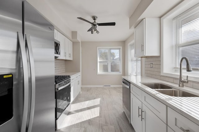 1367 Buffalo Ave, Calumet City, IL 60409 - kitchen with stainless steel appliances, a sink, light countertops, backsplash, and a ceiling fan