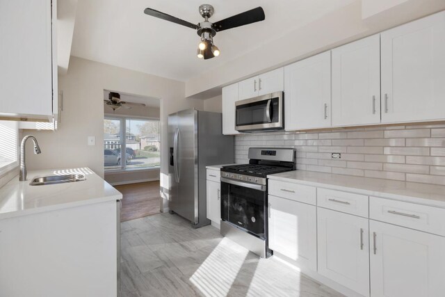 1367 Buffalo Ave, Calumet City, IL 60409 - kitchen featuring appliances with stainless steel finishes, ceiling fan, a sink, white cabinets, and decorative backsplash