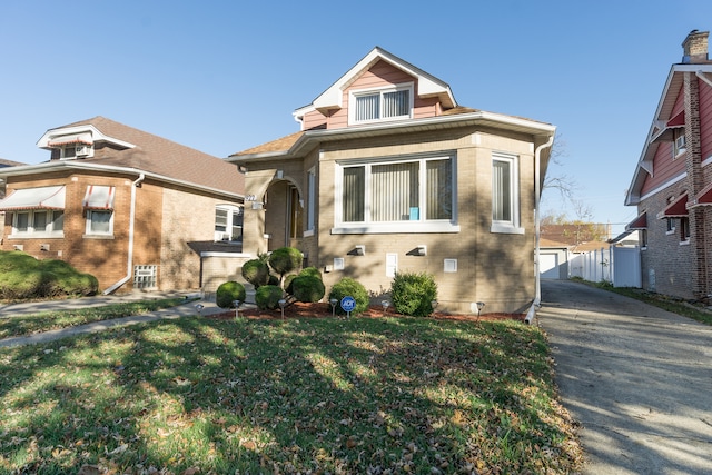 view of front of property featuring a front lawn, a garage, and an outdoor structure