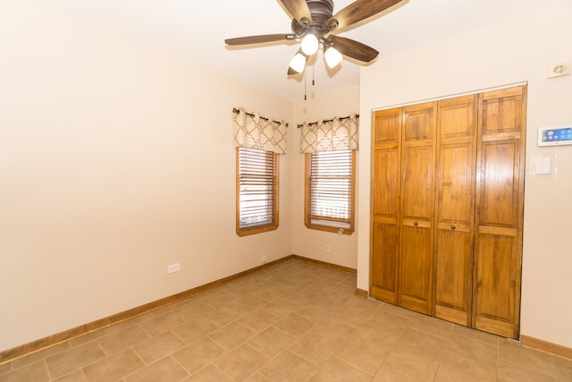 unfurnished bedroom featuring ceiling fan and a closet