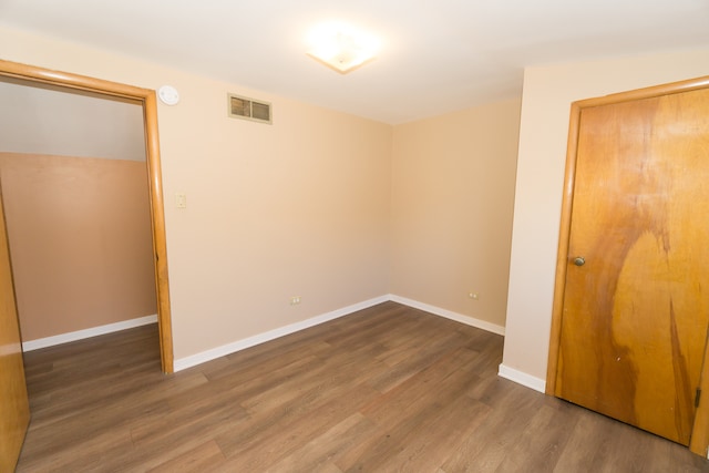 unfurnished room with dark wood-type flooring