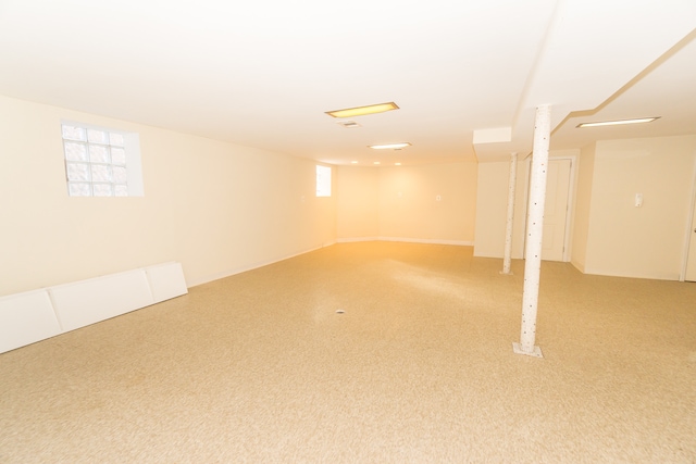 basement with a wealth of natural light and carpet flooring