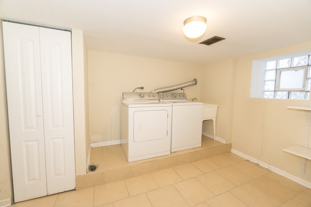 washroom featuring washing machine and dryer and light tile patterned floors