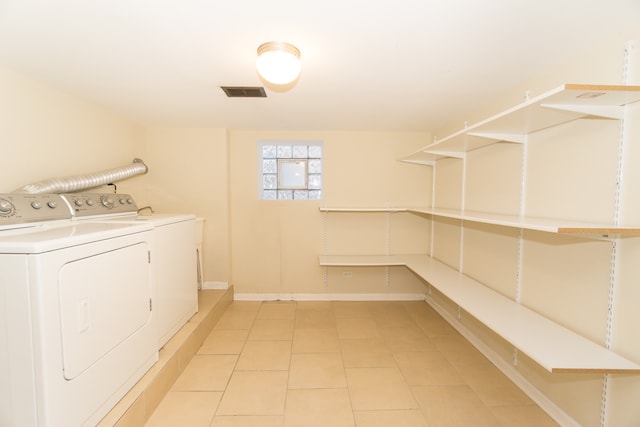 laundry area featuring washer and clothes dryer and light tile patterned floors