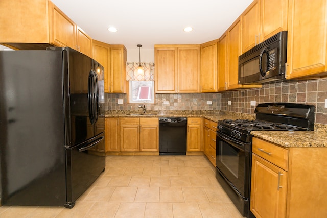 kitchen featuring black appliances, pendant lighting, sink, and stone countertops