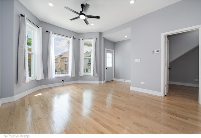 empty room featuring light hardwood / wood-style floors, ceiling fan, and a healthy amount of sunlight