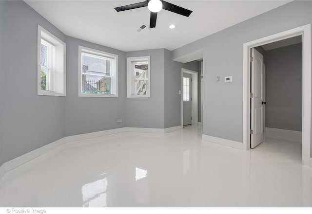 spare room featuring ceiling fan and plenty of natural light