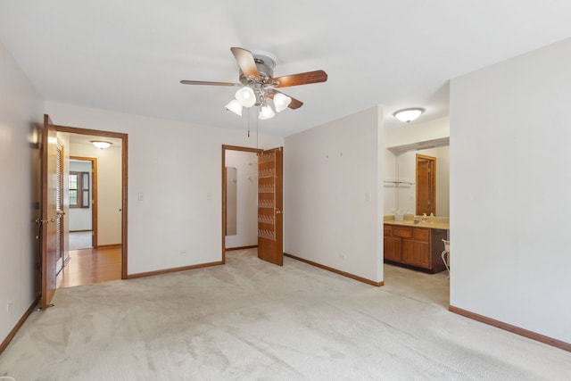 unfurnished bedroom with connected bathroom, light carpet, and ceiling fan