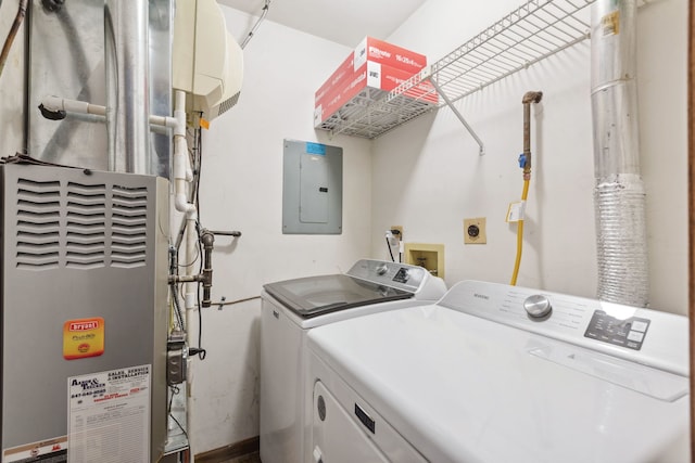 washroom with electric panel, washer and dryer, and heating unit