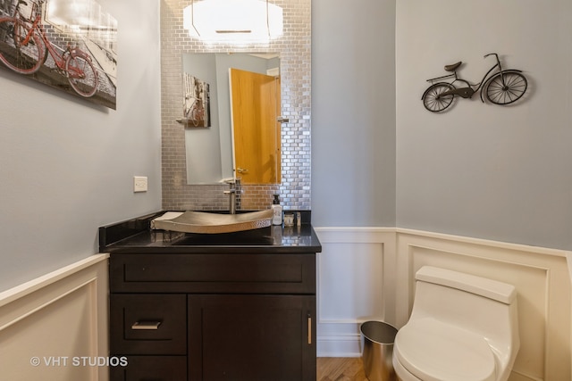 bathroom with decorative backsplash, vanity, wood-type flooring, and toilet