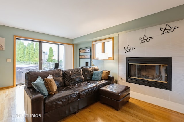 living room featuring hardwood / wood-style flooring and a tiled fireplace