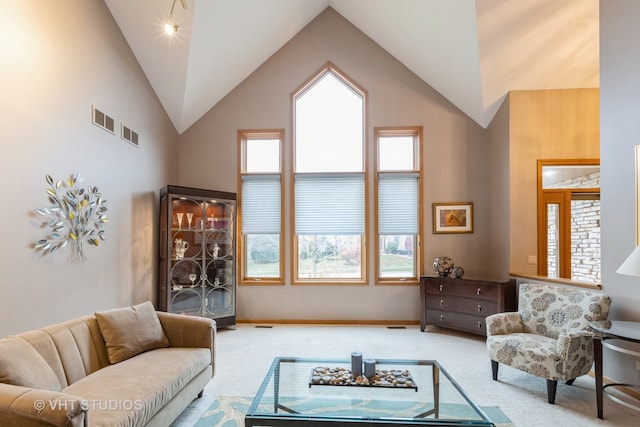 living room with carpet and high vaulted ceiling