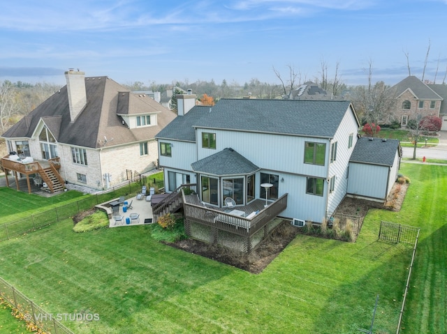 back of house with a yard, a sunroom, and a wooden deck