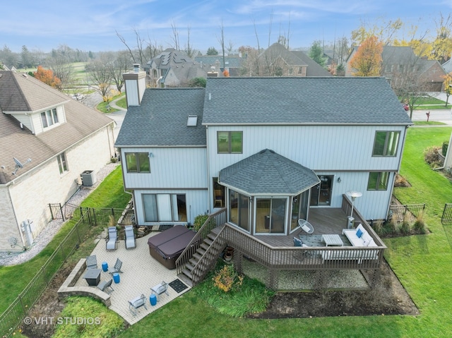 rear view of property featuring a yard, an outdoor hangout area, a hot tub, and a deck