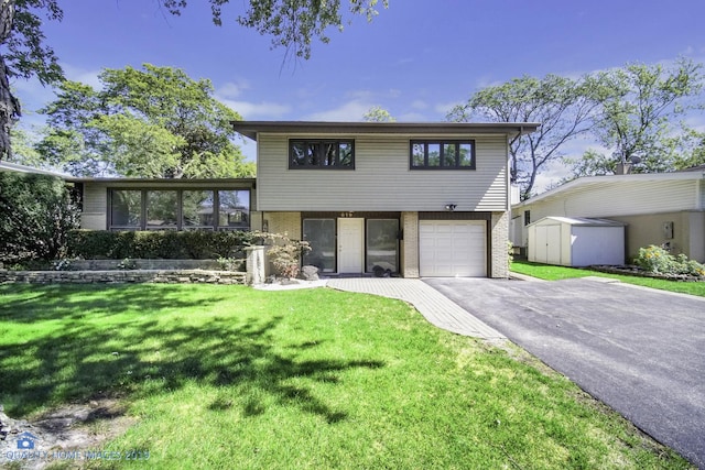 view of front of property with a storage unit, a garage, and a front lawn