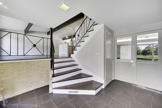 staircase featuring brick wall