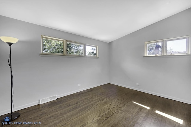 empty room featuring dark hardwood / wood-style floors and vaulted ceiling