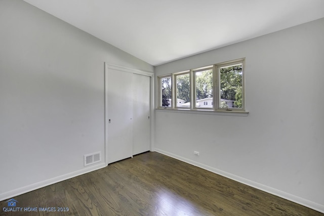 empty room featuring dark hardwood / wood-style flooring and lofted ceiling