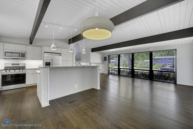 kitchen with white cabinets, a wealth of natural light, vaulted ceiling with beams, and appliances with stainless steel finishes