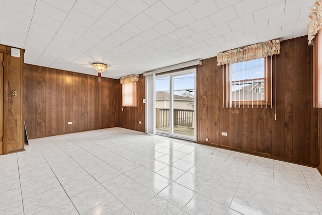 unfurnished room featuring wooden walls