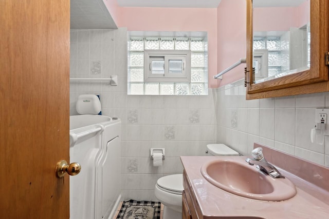 bathroom featuring vanity, toilet, and tile walls