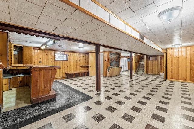 basement with white fridge and wooden walls