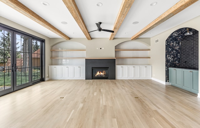 unfurnished living room with light wood-type flooring, ceiling fan, and beam ceiling