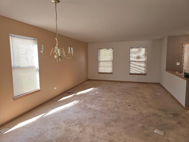 unfurnished dining area featuring plenty of natural light, carpet flooring, and a notable chandelier