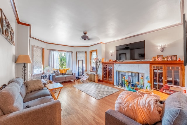 living room featuring hardwood / wood-style floors, ceiling fan, and ornamental molding