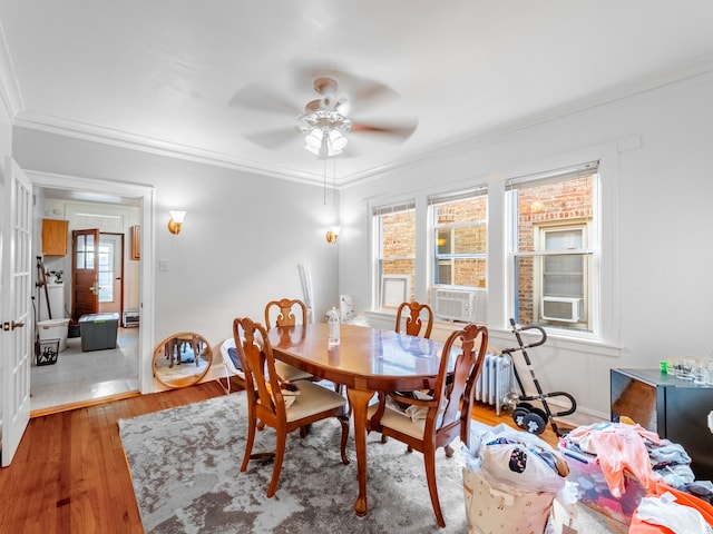 dining room with cooling unit, hardwood / wood-style floors, ceiling fan, and crown molding