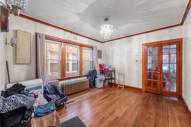 miscellaneous room featuring radiator, hardwood / wood-style floors, ornamental molding, and french doors