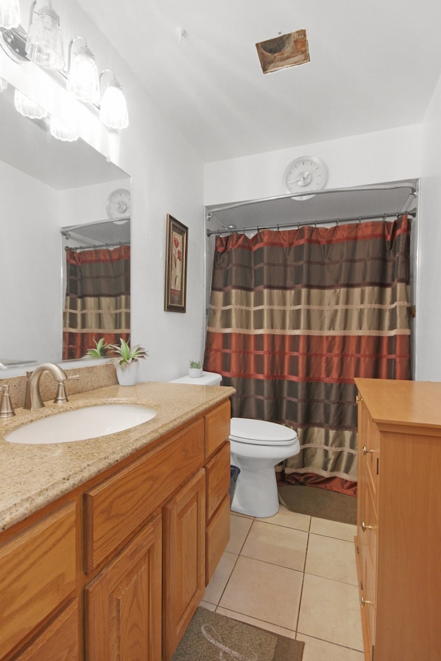 bathroom with tile patterned flooring, vanity, and toilet