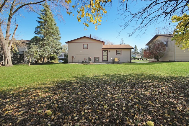 back of property featuring a lawn