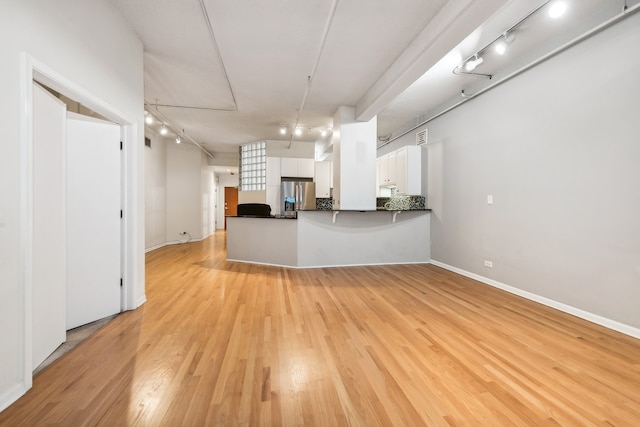 kitchen featuring white cabinets, light wood-type flooring, stainless steel fridge with ice dispenser, and kitchen peninsula