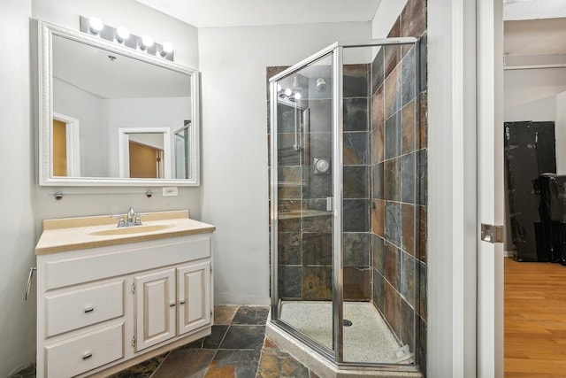 bathroom featuring walk in shower, vanity, and hardwood / wood-style flooring