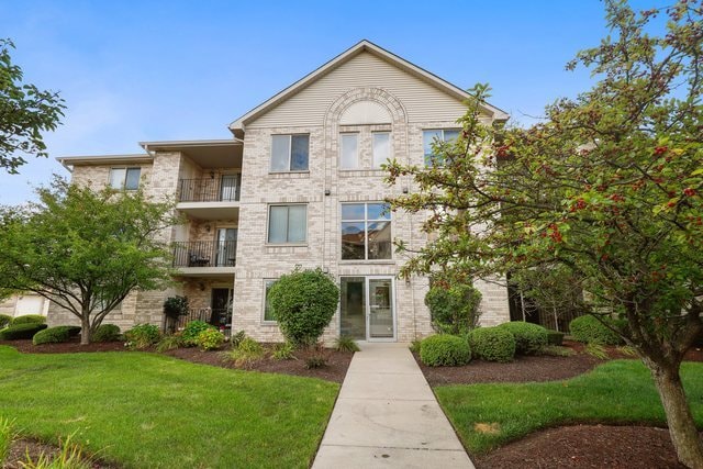 view of front of home with a front yard and a balcony