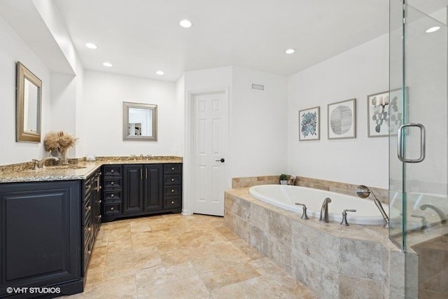 bathroom featuring vanity and independent shower and bath