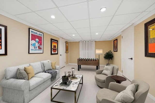 living room with a paneled ceiling and carpet flooring