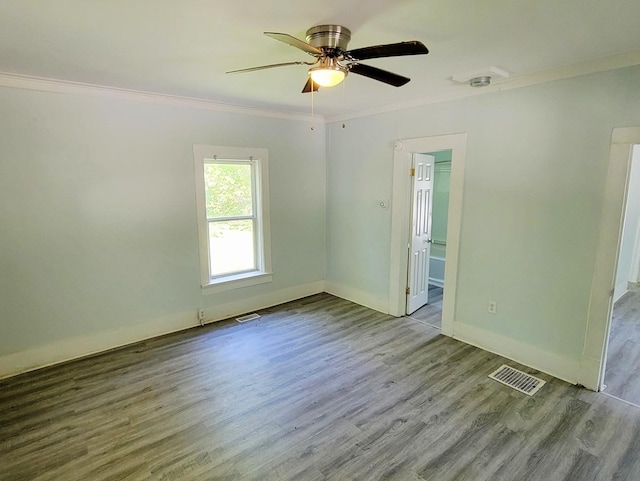 unfurnished room with ornamental molding, wood finished floors, baseboards, ceiling fan, and a smoke detector