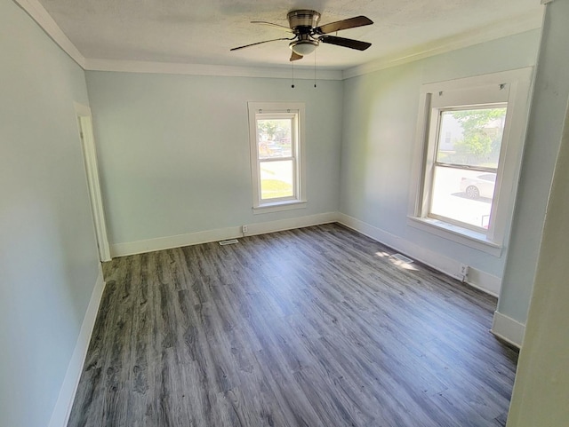 unfurnished room with healthy amount of natural light, wood finished floors, ornamental molding, a ceiling fan, and baseboards