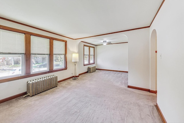 carpeted empty room with radiator heating unit, ceiling fan, and ornamental molding