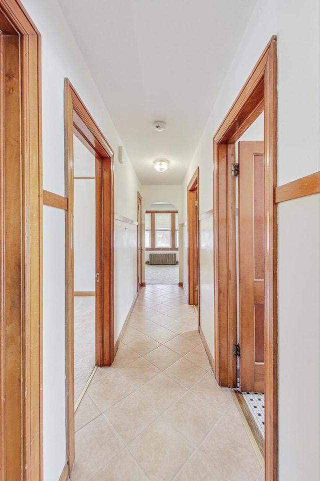 corridor featuring radiator heating unit and light tile patterned floors