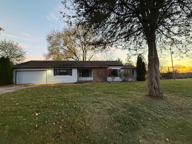 ranch-style house featuring a yard and a garage