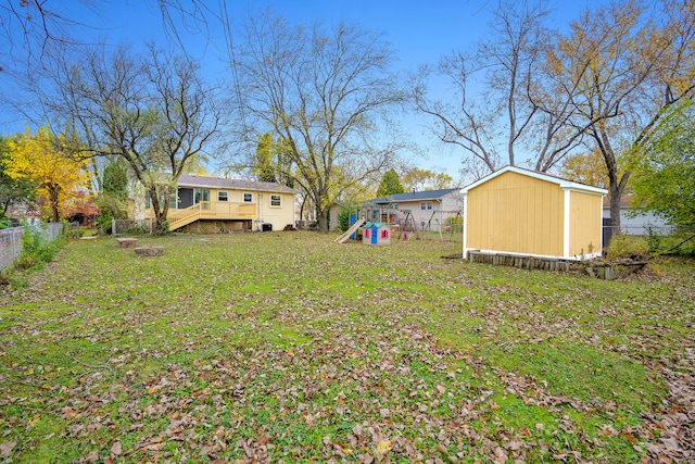 view of yard with a playground, a shed, and a deck